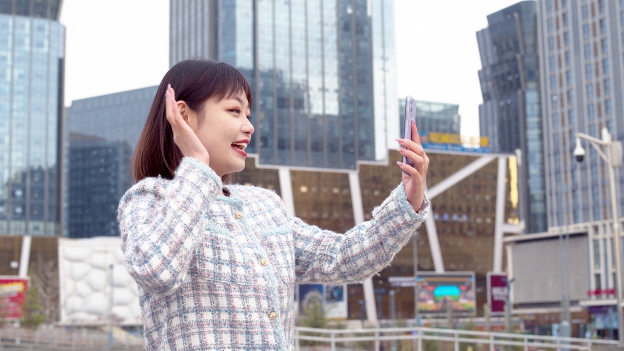 亚洲年轻女子在城市街道上使用智能手机视频素材