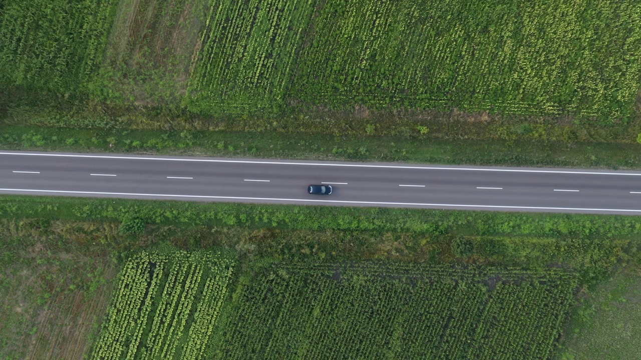 自行车和汽车在道路上延伸，通过耕种的乡村景观，航拍视频素材