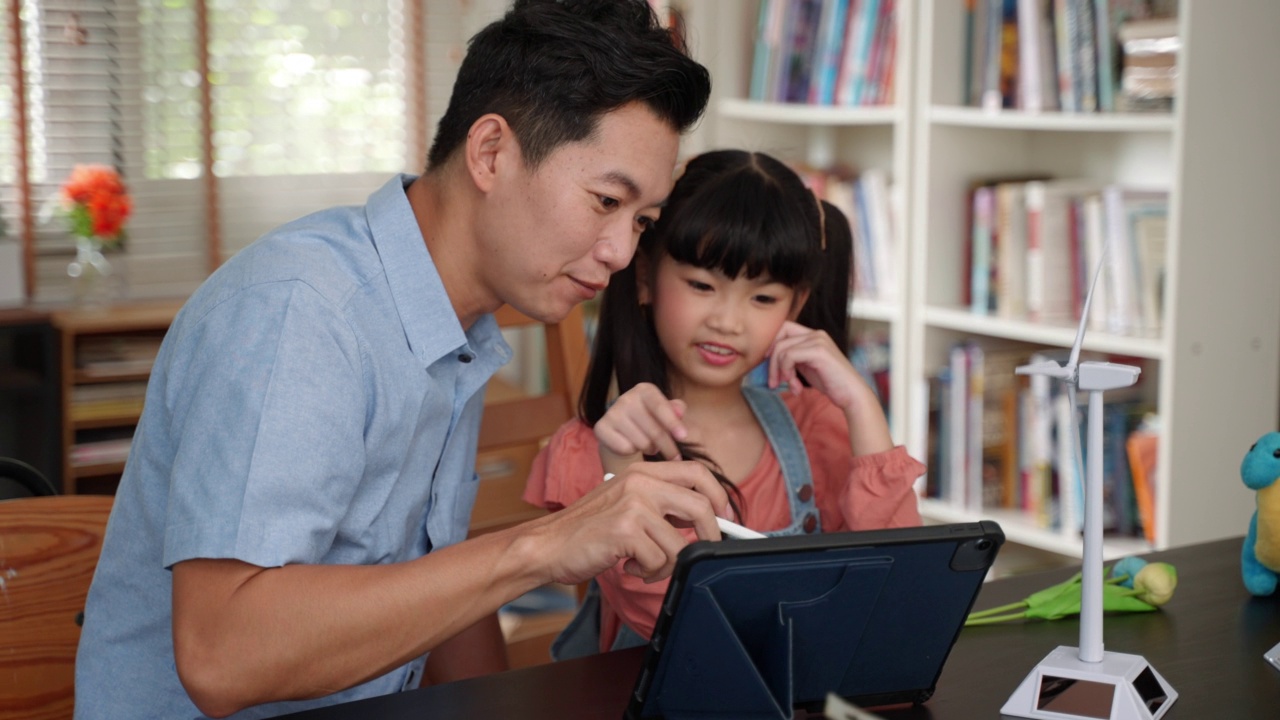 亚洲单亲父亲用风力发电机模型教女儿清洁能源的可持续性视频素材画面4