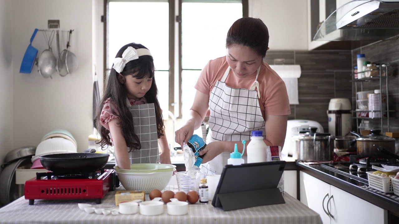 妈妈和女儿在厨房里做煎饼视频素材