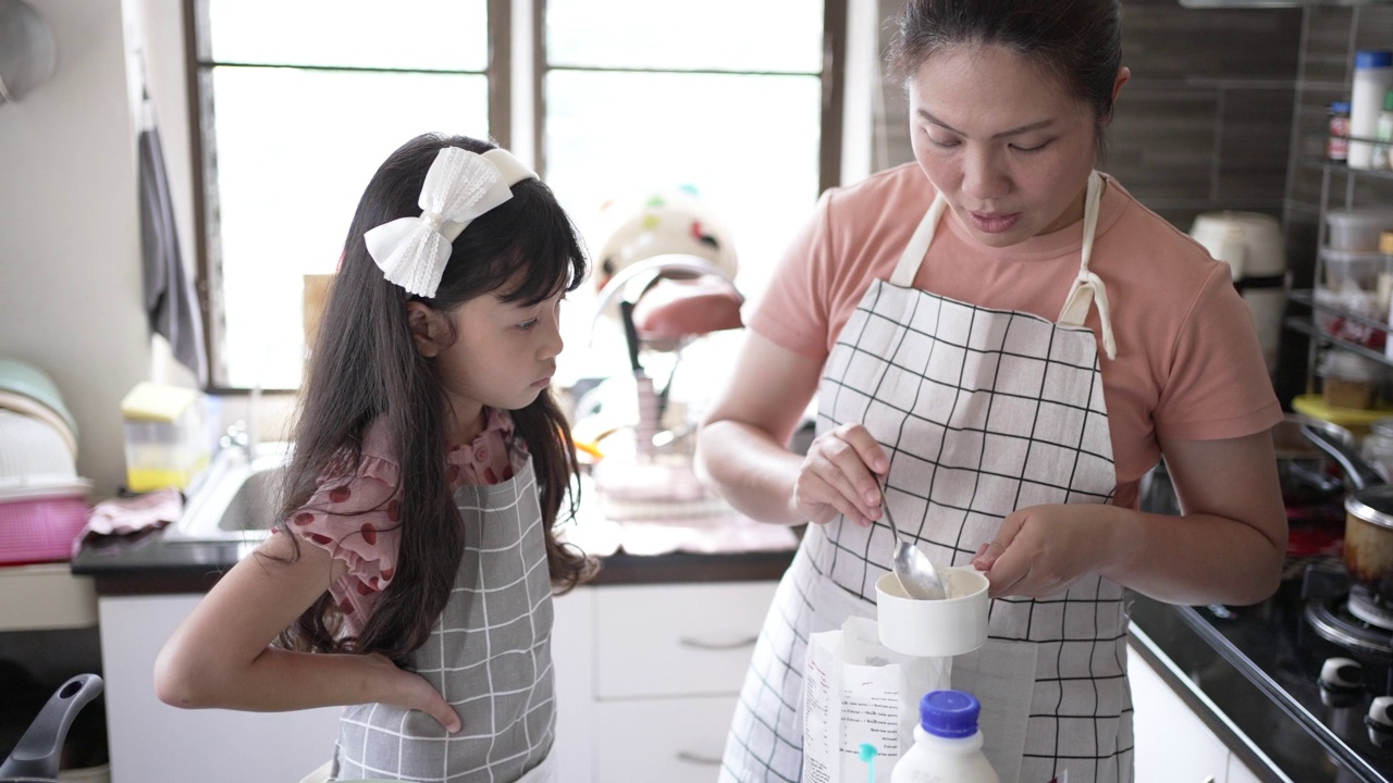 妈妈和女儿在厨房里做煎饼视频素材