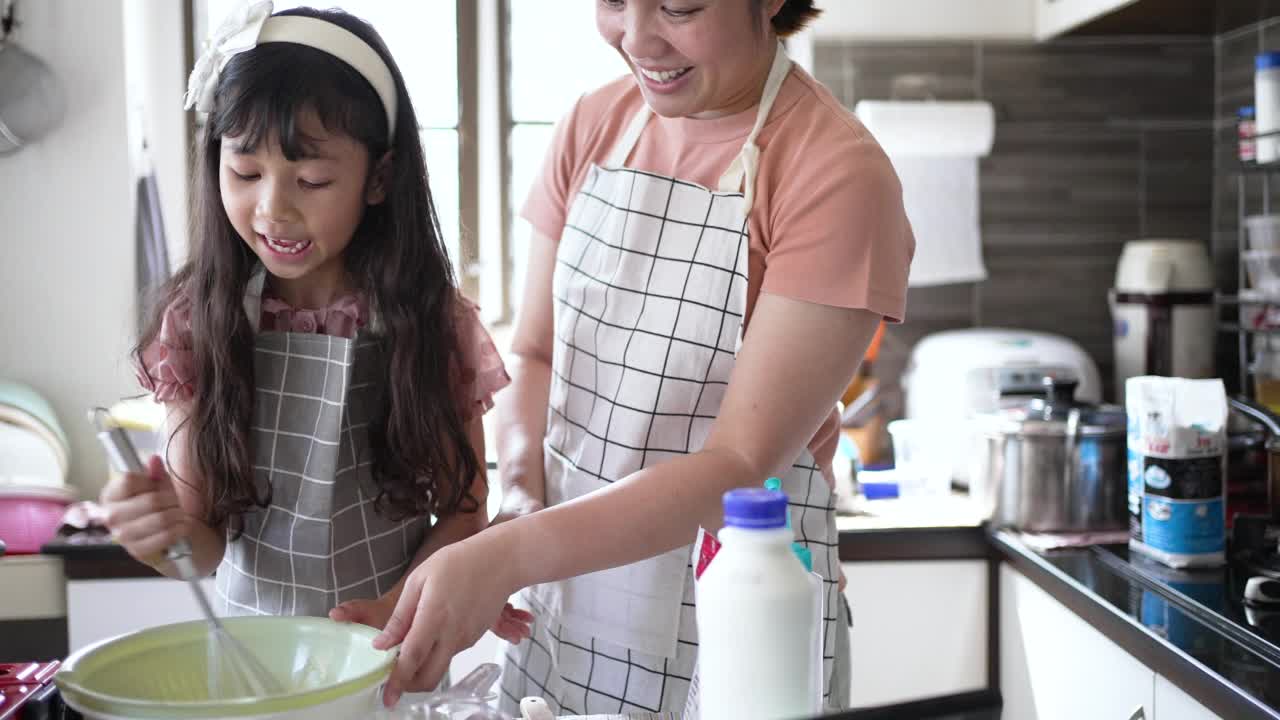 妈妈和女儿在厨房里做煎饼视频素材