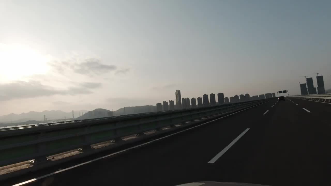 从行驶的汽车上往外看，进入河上大桥的道路视频素材