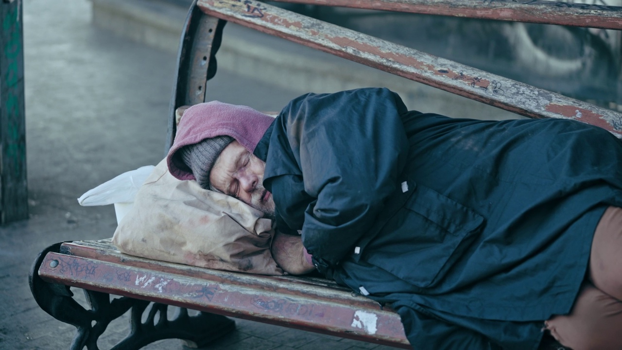 孤独的男性难民睡在长凳上，需要紧急住宿，贫困视频素材