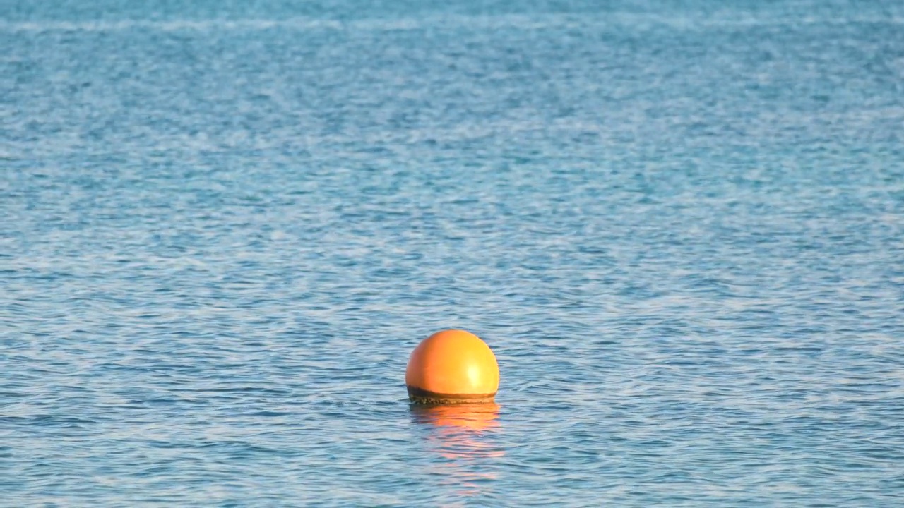 漂浮在海面波浪上的橙色浮标。人的生命安全观视频素材