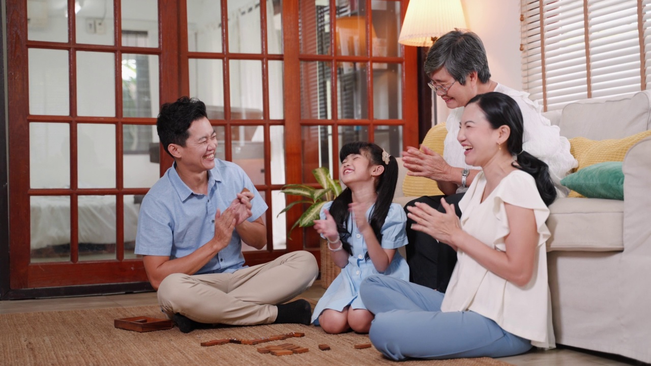 亚洲家庭与年轻女孩和老年妇女一起在公寓玩游戏视频素材