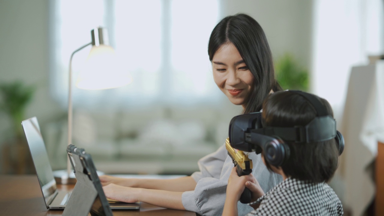 亚裔妈妈上班，亚裔女儿将来会戴眼镜。视频素材画面2