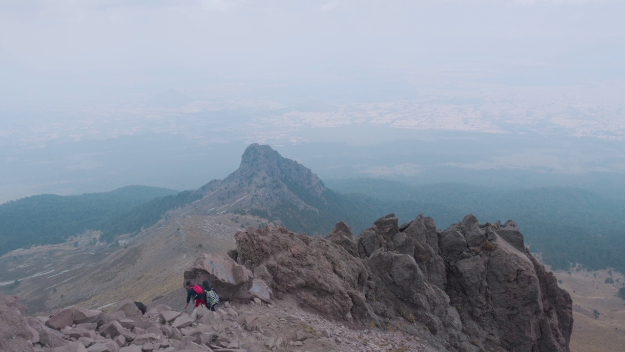 年轻的背包客在云端的山顶上徒步旅行视频素材