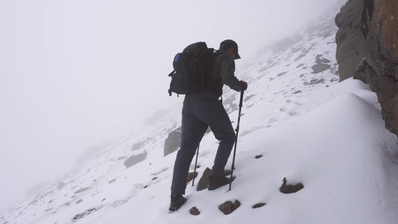 一个男人走在雪坡上视频素材