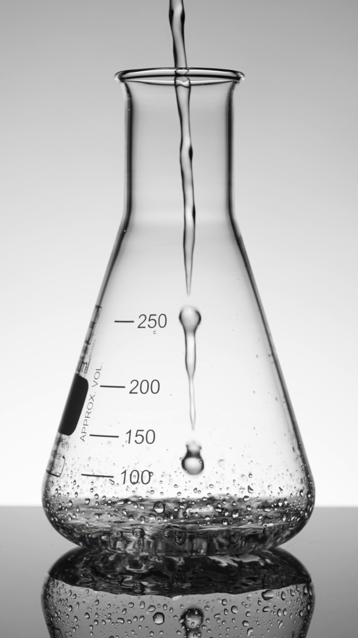 垂直科学家将液体倒入锥形烧瓶视频素材