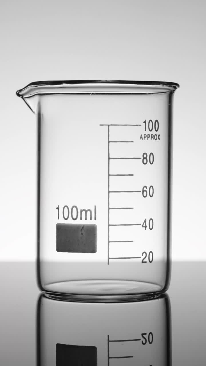垂直科学家将液体倒入烧杯视频素材