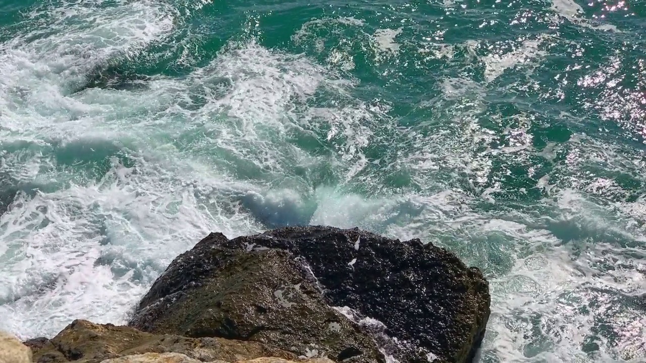 大海蓝色的海浪拍打着岩石，慢动作视频素材