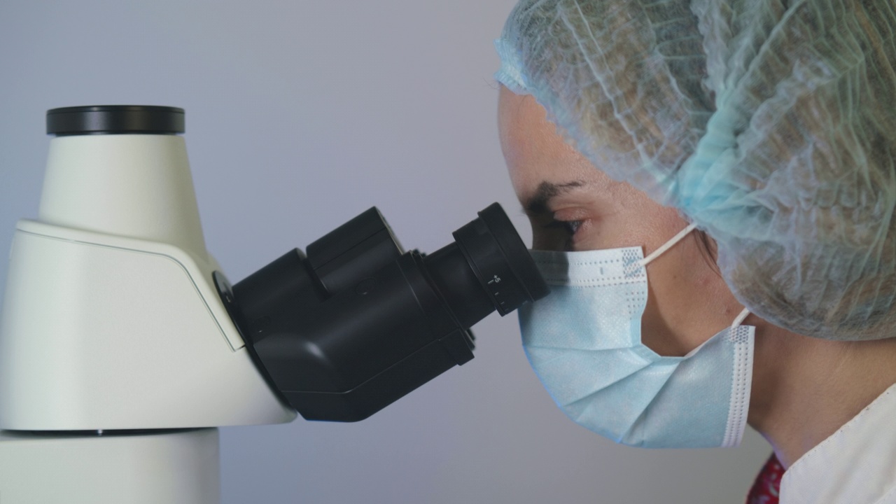 医学发展实验室:女科学家在显微镜下观察，分析生物样本。视频素材