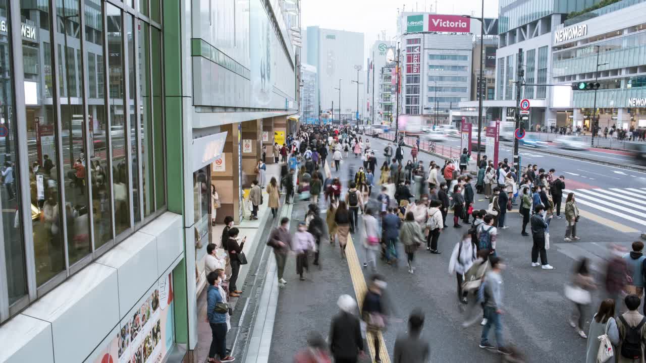 在东京新宿火车站附近，人们在人行道上行走的延时视频视频下载