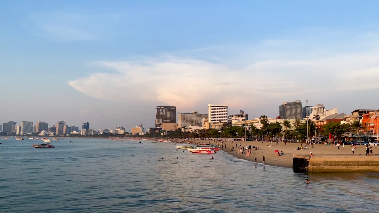 芭堤雅海滩日落创造了戏剧性的美丽天空反射穿过温和的波浪在海滨港口。为泰国旅游，度假，健康和健康营销主题建立异国情调的镜头和概念片视频素材