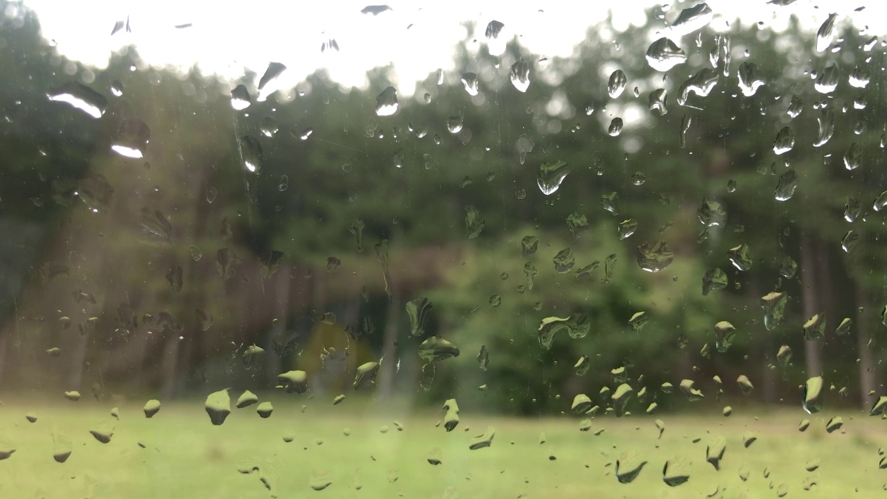 雨滴跑下来。水滴顺着玻璃窗流下来。视频素材