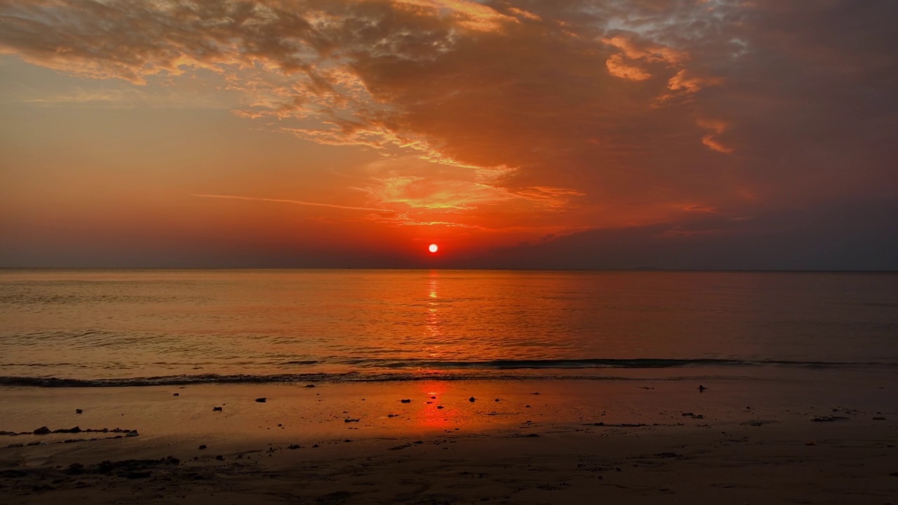 美丽的金色夕阳，平静的大海。橙色的太阳在地平线附近。视频素材