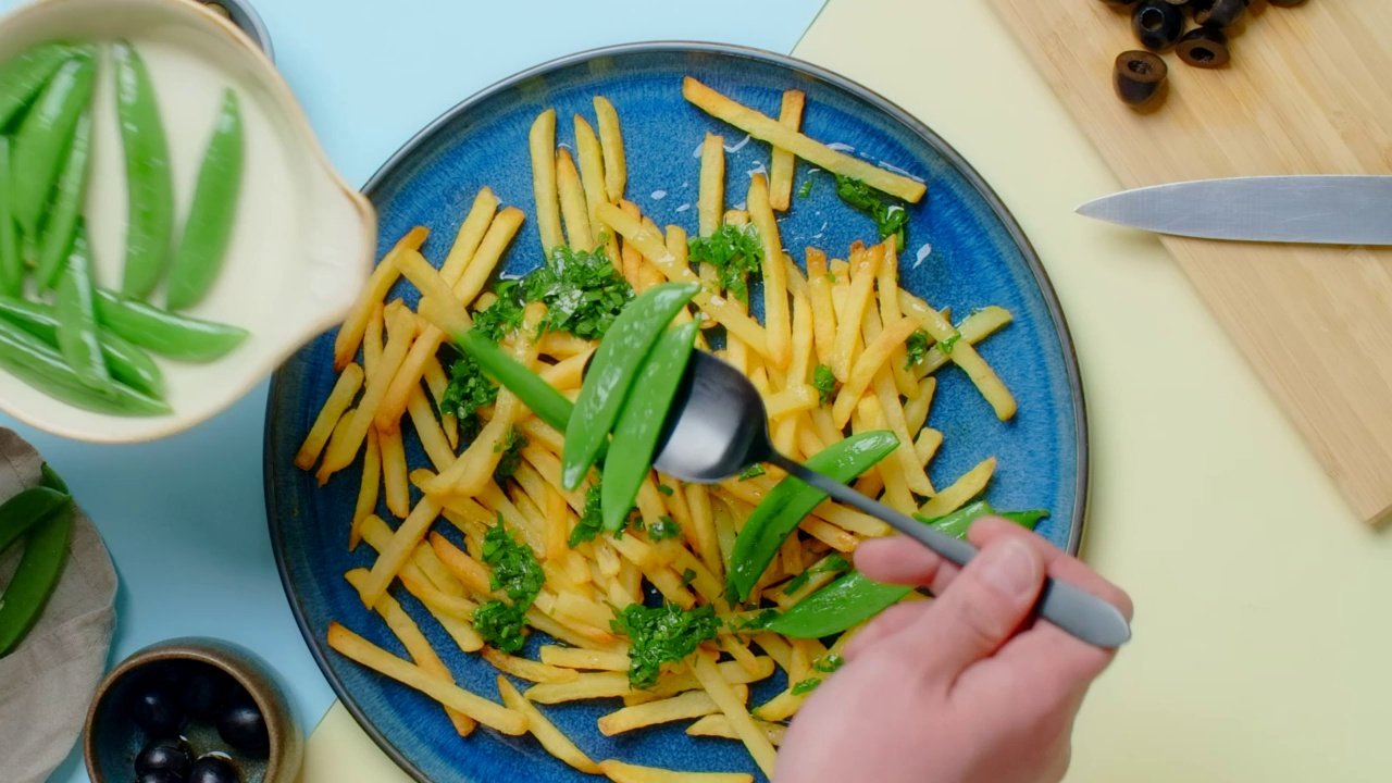 垂直桌面视频:厨师添加甜豌豆荚油炸土豆菜视频素材