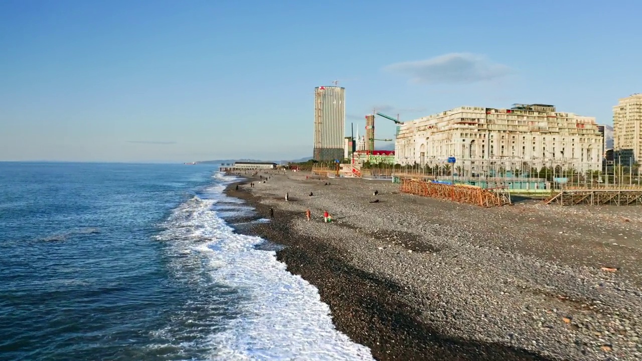 沿着黑海海滩和巴统市的现代街区飞行视频素材