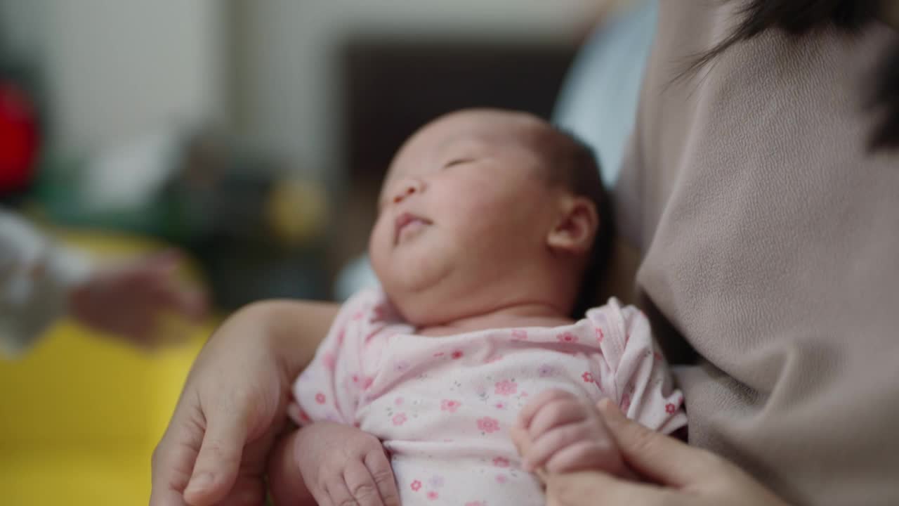 可爱的弟弟亲吻着妈妈膝上的弟弟。视频素材