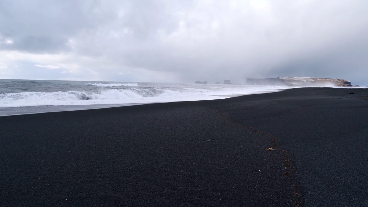 冬季多云天气，冰岛Vík í Mýrdal附近雷尼斯菲加拉黑色海滩强劲的海浪。视频下载