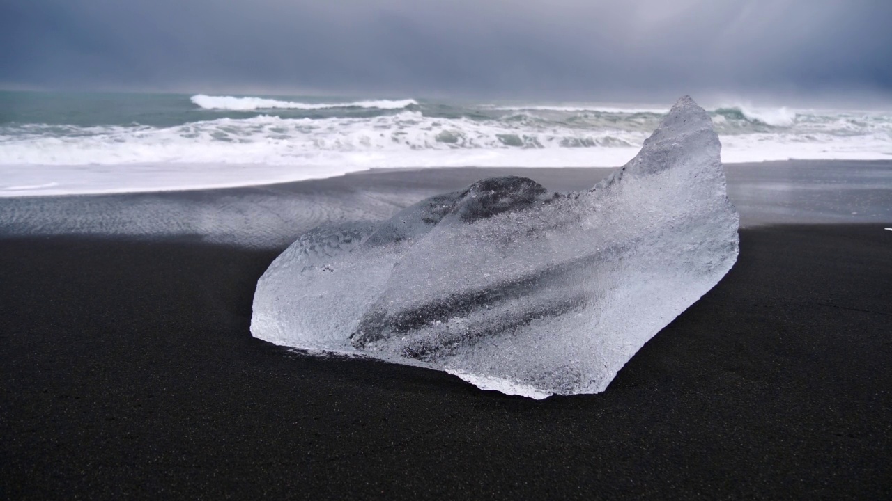 美丽的小冰山，在Jökulsárlón附近的钻石海滩和环冰岛南部与汹涌的大西洋的背景清楚的冰表面。视频素材