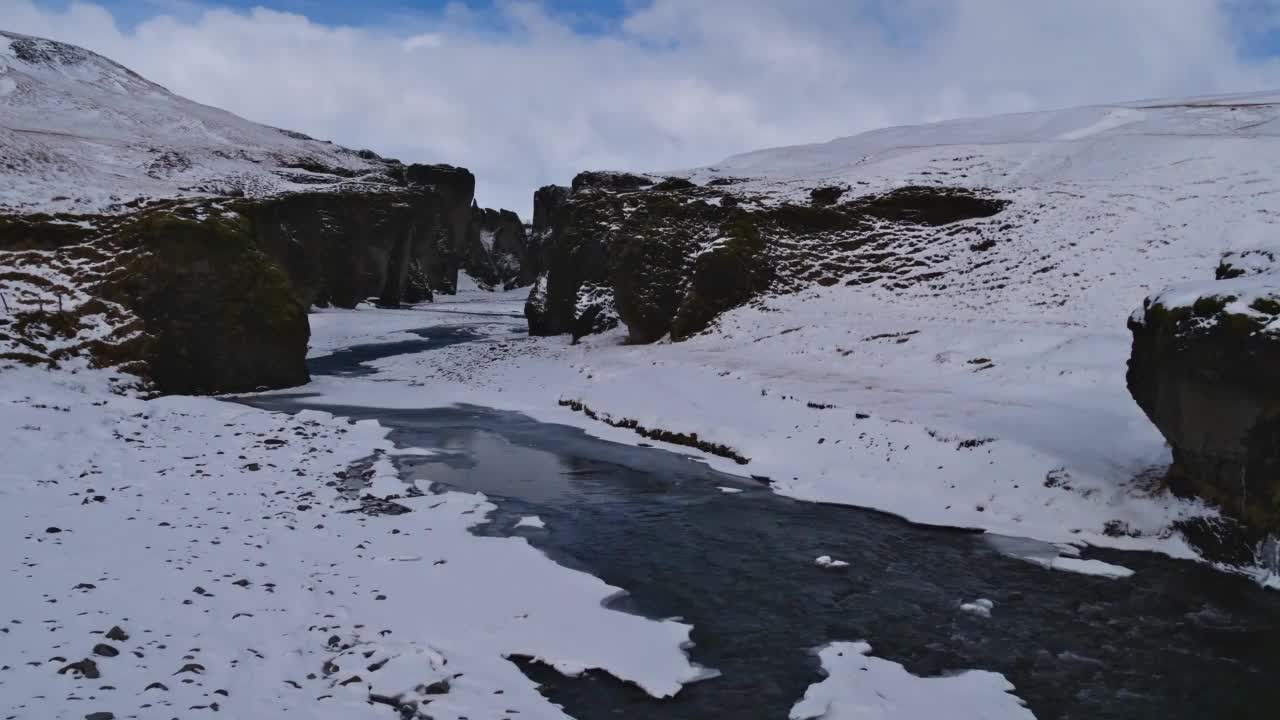 冰岛南部著名峡谷Fjaðrárgljúfur入口的迷人景色，附近环路，被雪覆盖的岩石，陡峭的悬崖和蜿蜒的Fjaðrá河。视频下载