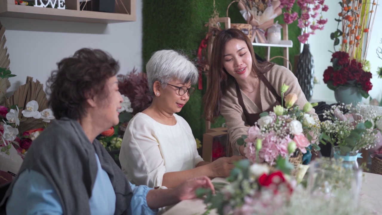 亚洲华人女花商在她的工坊班向她的成年高年级学生展示插花视频素材画面1