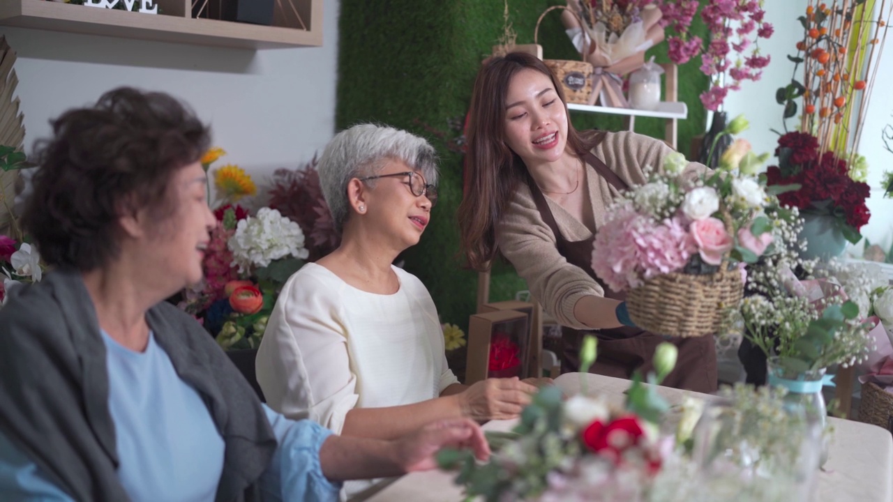 亚洲华人女花商在她的工坊班向她的成年高年级学生展示插花视频素材画面2