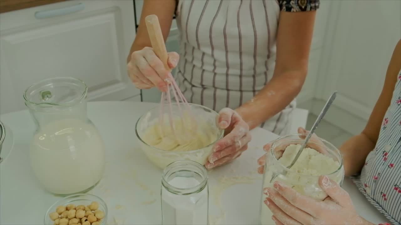 母亲和女儿一起准备面团。有选择性的重点。食物。视频素材