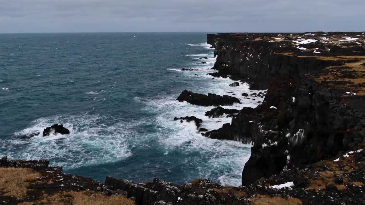 Svörtuloft悬崖峭壁在Snæfellsnes半岛西北海岸，冰岛西部冬季，崎岖的火山岩，强劲的海浪和飞翔的海鸟。视频下载