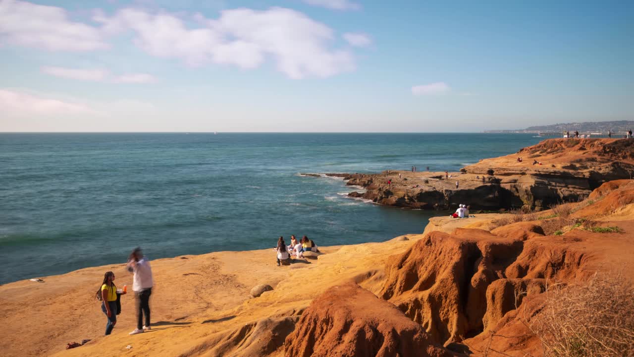 夫妻和游客在太平洋享受日落峭壁的时间流逝。视频素材