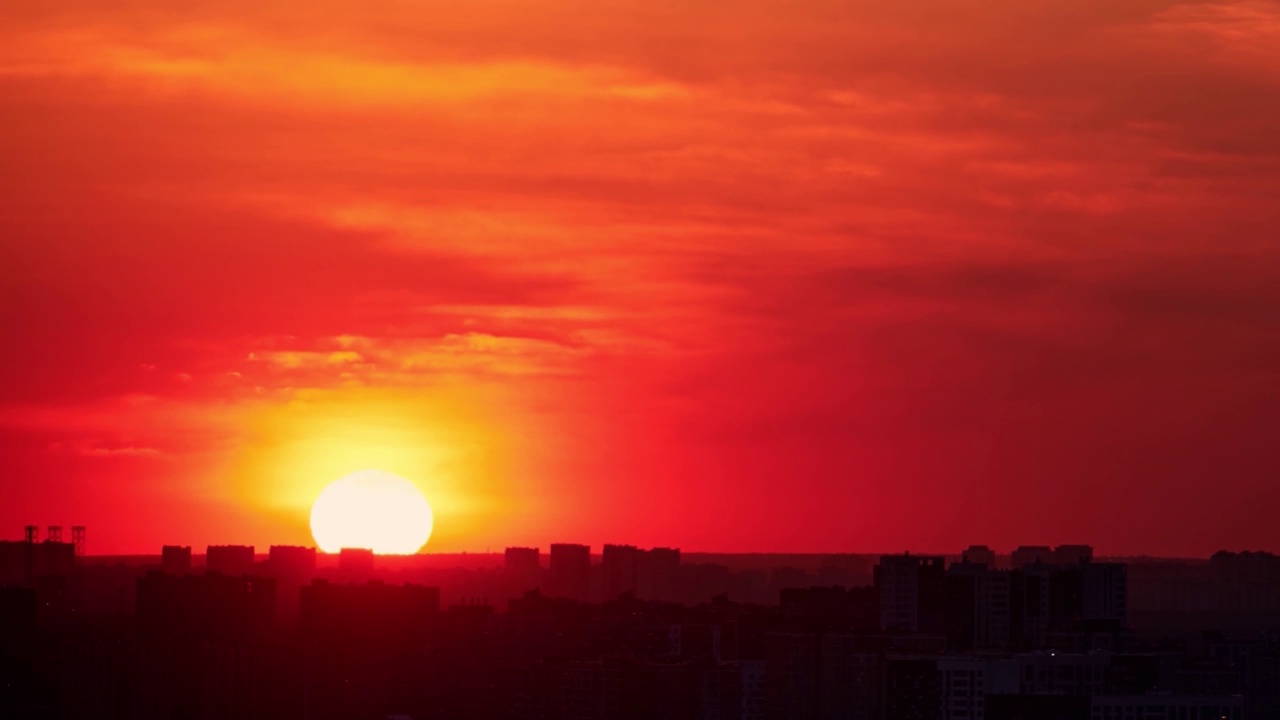 黎明时分，清晨的天空伴随着一轮巨大的太阳冉冉升起在城市上空，日出时分，时间流逝视频素材