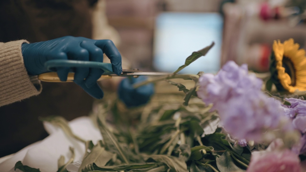 亚洲华人女花商，小企业主在花店切割和安排花束。日常经营小生意视频素材画面1