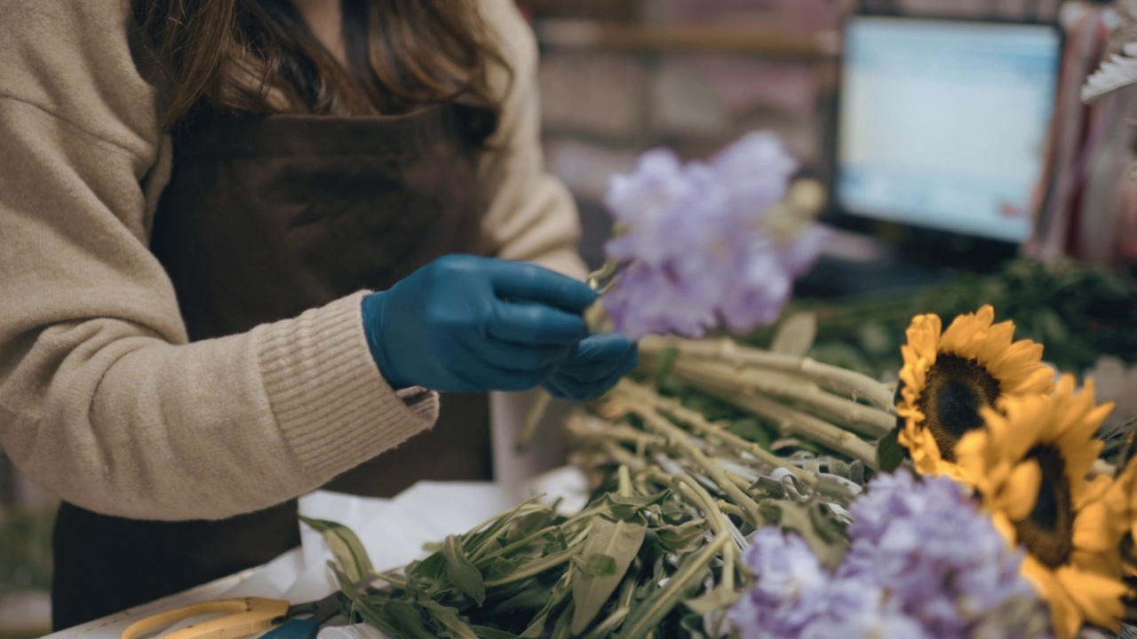 亚洲华人女花商，小企业主在花店切割和安排花束。日常经营小生意视频素材画面1