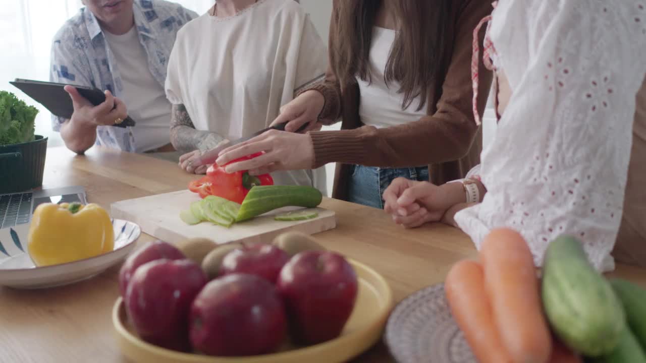 亚洲家庭在厨房里互相帮助做饭视频素材