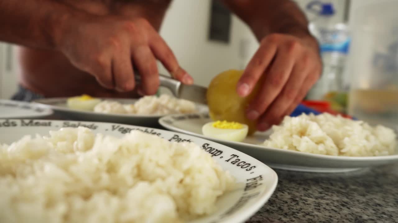 特写镜头将食物放在几个盘子里，用刀和手在厨房里切土豆视频素材