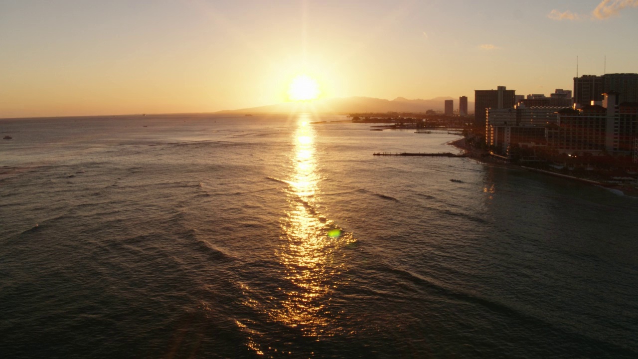 在威基基海滩/夏威夷火奴鲁鲁日落时，WS HA在冲浪者上空的航拍视频素材