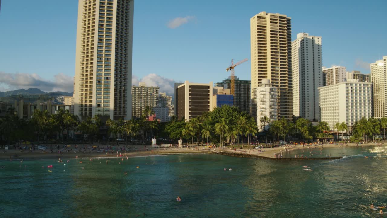 在威基基海滩/夏威夷火奴鲁鲁日落时，WS HA在冲浪者上空的航拍视频素材