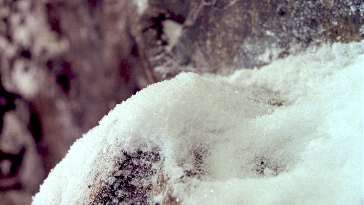 岩石或雪山表面覆盖粉末状雪的近角度。视频素材