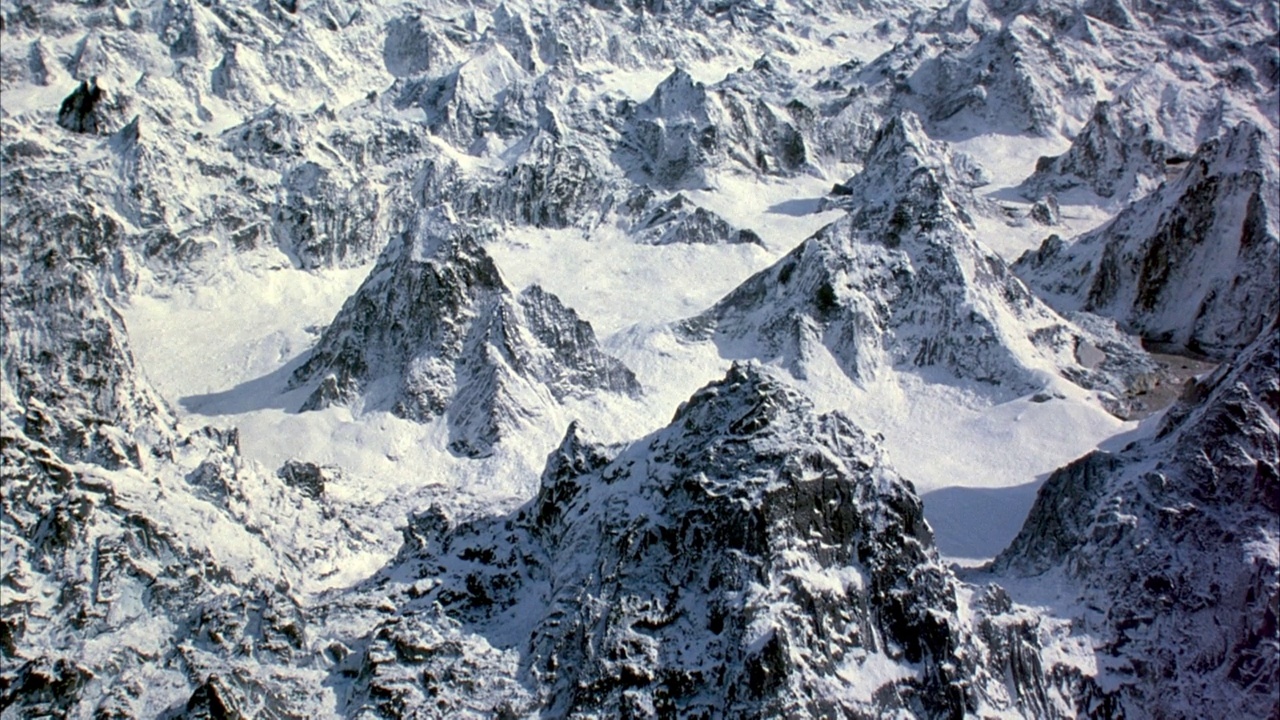 广角的雪山环绕着平坦的雪域，中心是两座孤零零的山。视频素材