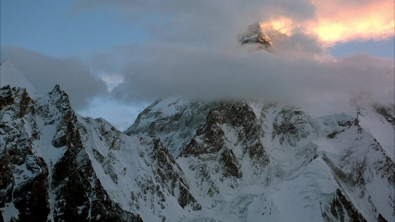 广角雪山建立。看山周围的云。看到晴朗的天空。视频素材