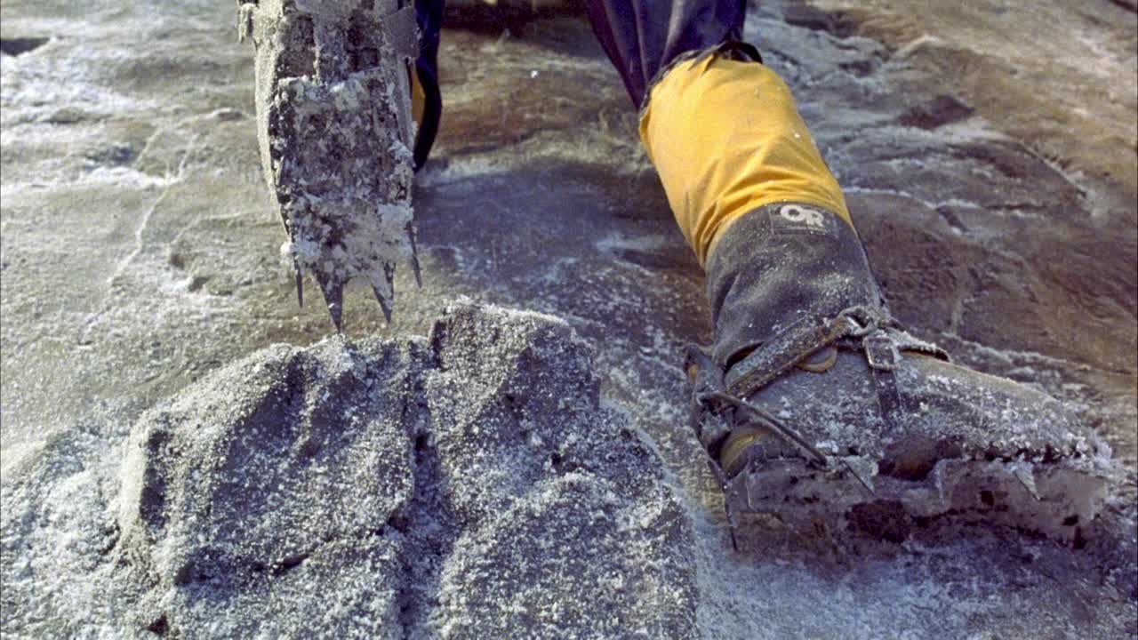 当登山者被压在白雪覆盖的灰色岩壁上时，登山靴在壁架上的闭合角度。看到雪崩的降雪和左边靴子滑作为窗台断裂。行动。视频素材