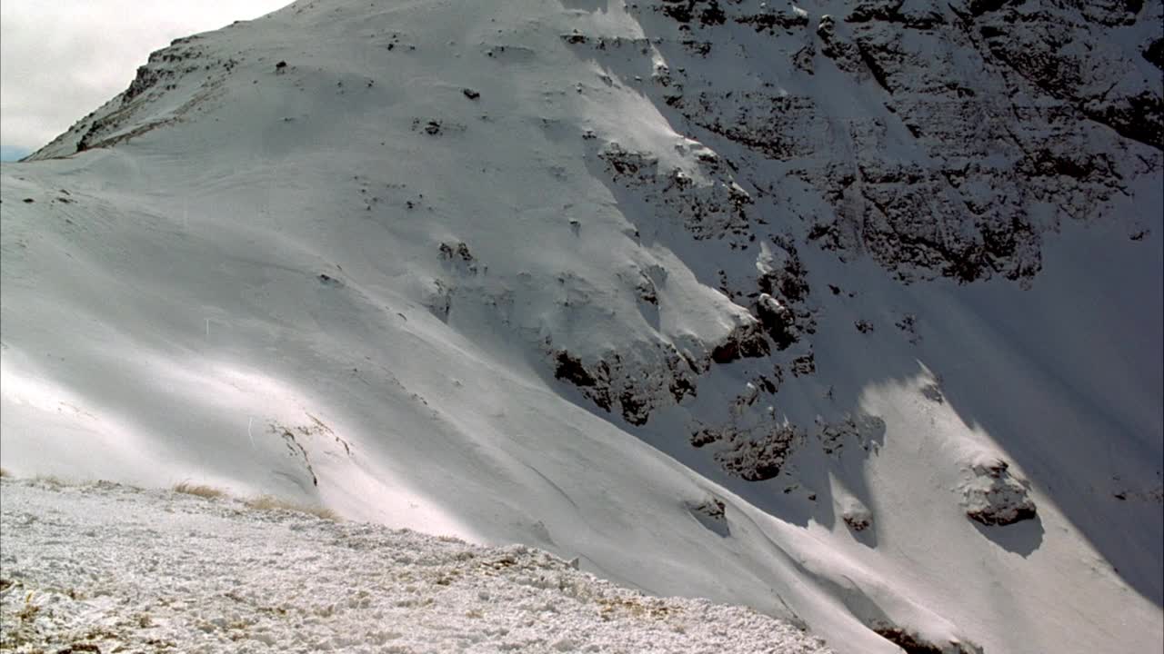 雪山山峰和斜坡的中等角度。被阴影覆盖的斜坡接近pov。视频素材