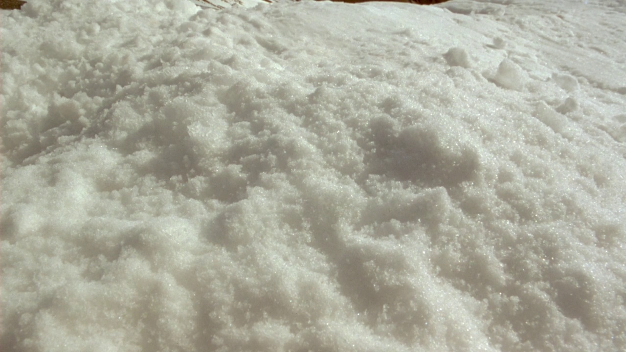 地面上雪的中等角度。看红色杆子在雪中爆炸。看pov沿着极点的轨迹向上。看到红色液体或血液的塑料袋绑在杆的顶部，红色塑料飘带飘扬。在背景中可以看到蓝天和积云。经验值视频素材