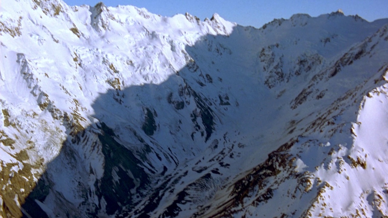 空中的积云海。在右边可以看到透过云层的雪山山峰。看白雪覆盖的山脉。在背景中看到清澈的蓝天。视频素材