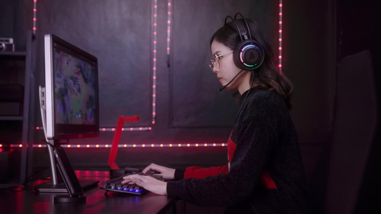 年轻女性专业Streamer和玩家与耳机玩在线视频游戏视频素材