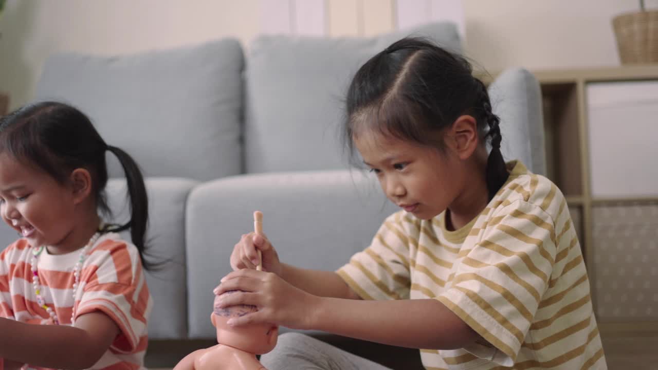 快活的女孩子们在家里一起玩洋娃娃视频素材