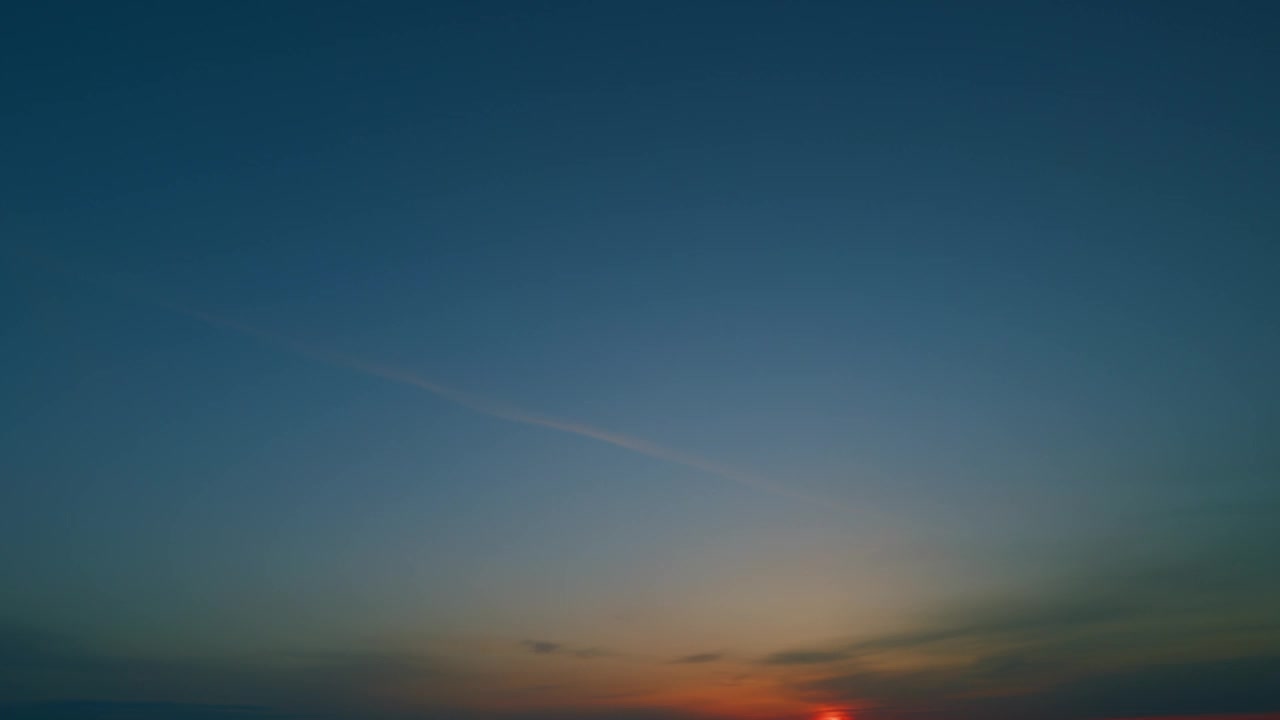 太阳从地平线上升起。五彩缤纷的日出蓝色的天空与淡橙色的云在金黄色的云景。时间流逝。视频素材