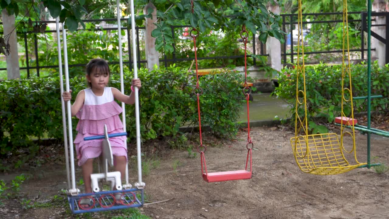 小女孩在公园的操场上荡秋千视频素材